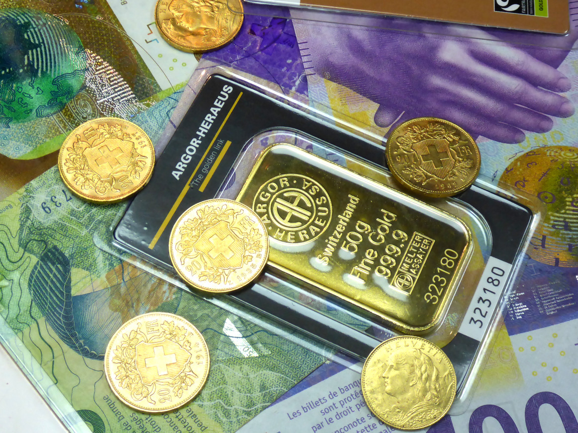 Pièces d'or et lingots d'or posés sur des billets de banque © PreMeSec Sarl